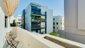 A modern apartment building with balconies, outdoor seating, and potted plants. - Double O apartment - Near the bech (Tel Aviv)