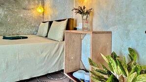 A cozy bedroom with a bed, pillows, a wooden nightstand, a vase with plants, and two hanging lamps. - Nethu freedom cottage (Ahangama)