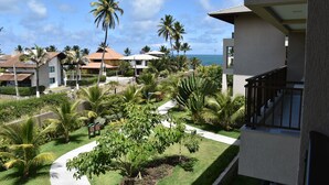 A resort with a well-maintained garden, palm trees, and a view of the ocean. - Eco Life Porto De Galinhas (Ipojuca)
