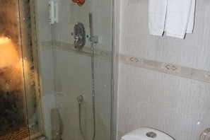 A glass-enclosed shower with a handheld showerhead and a wall-mounted faucet. - Zheng Tai He East Hotel (Liaocheng)