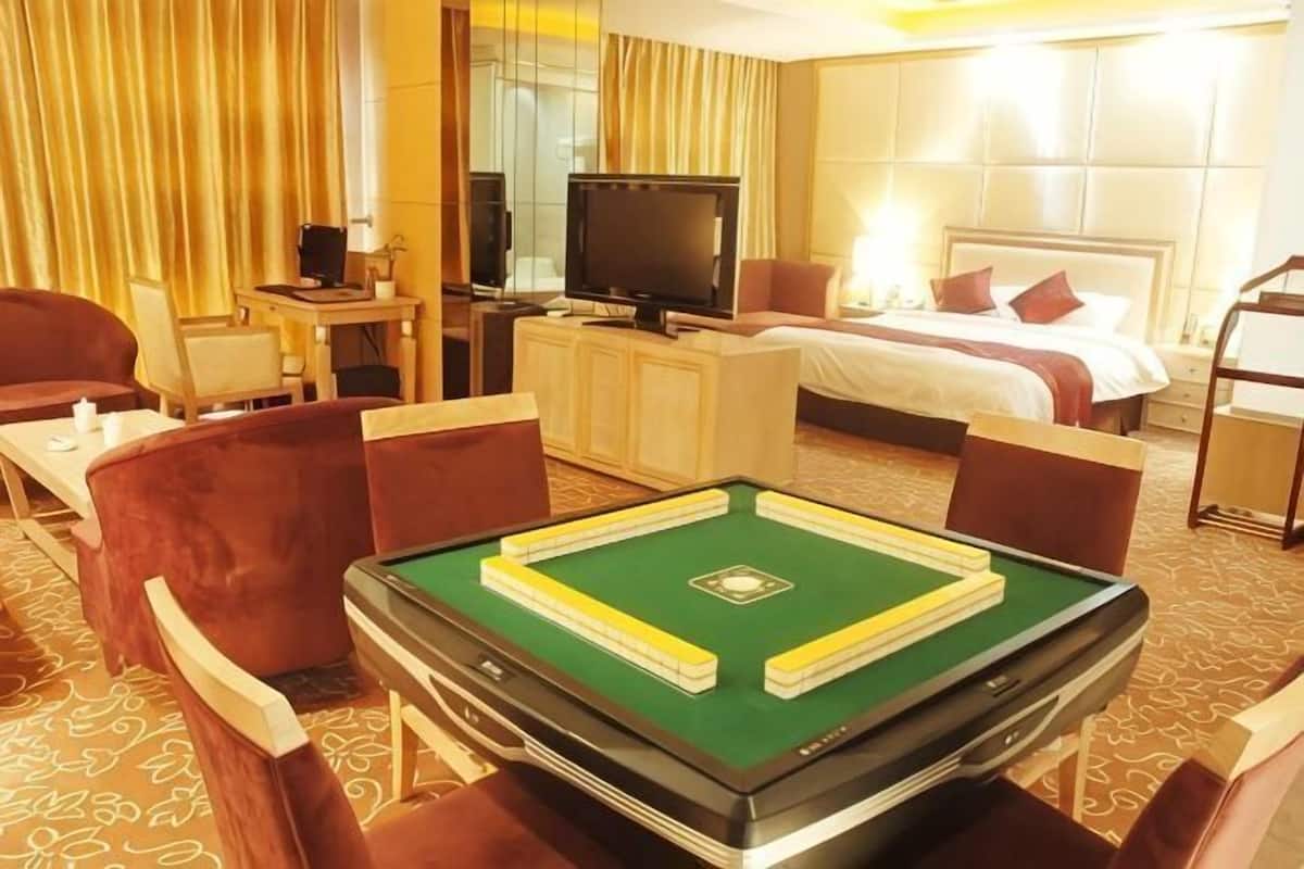 Une chambre d’hôtel équipée d’une table de billard, d’un téléviseur, d’un lit et d’un bureau.