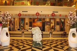 Un hall d’entrée avec un comptoir d’enregistrement, des vases décoratifs et un sol à motifs.