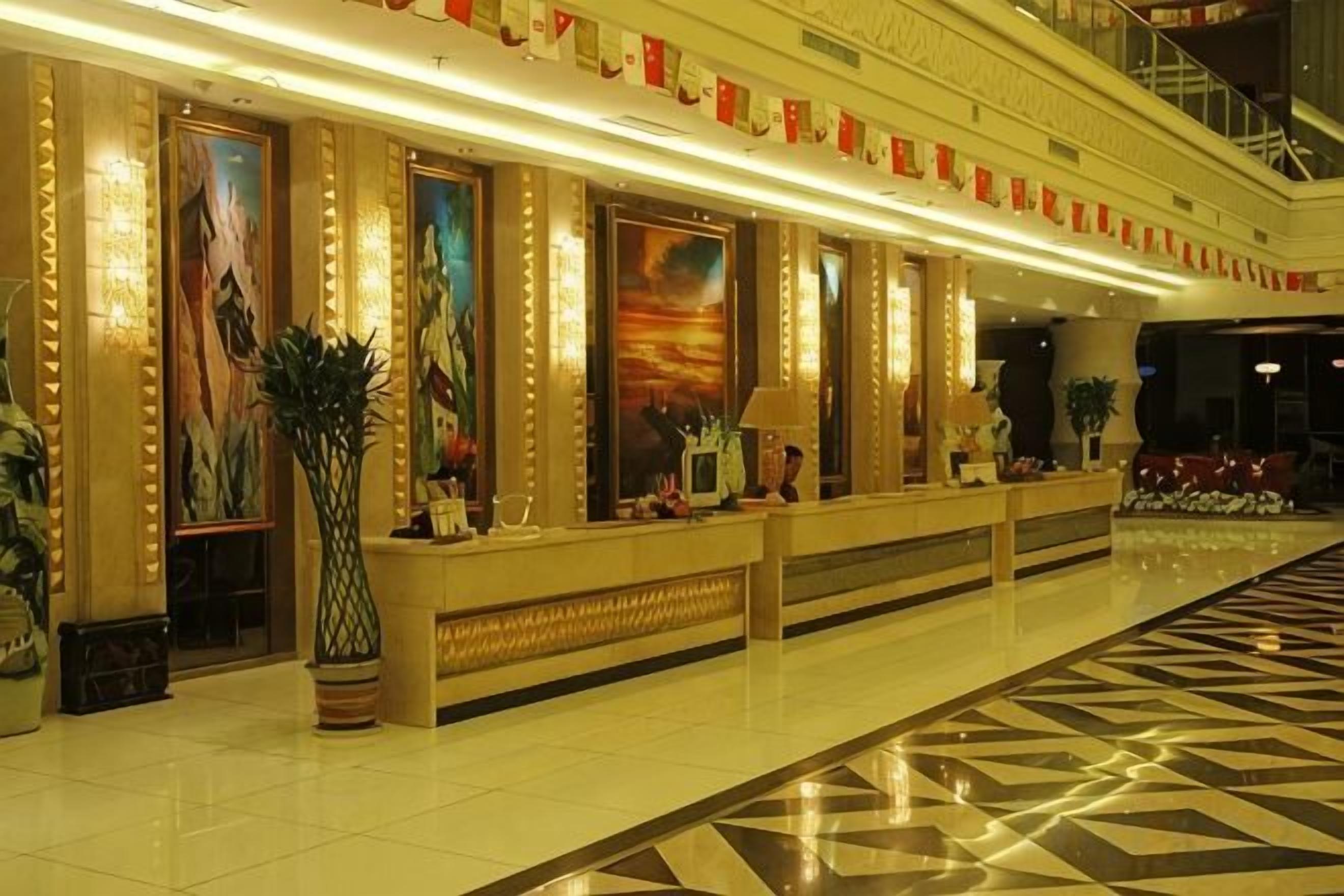 Un hall de hotel con mostrador de recepción, una obra de arte enmarcadas de gran tamaño y un mostrador de registro.