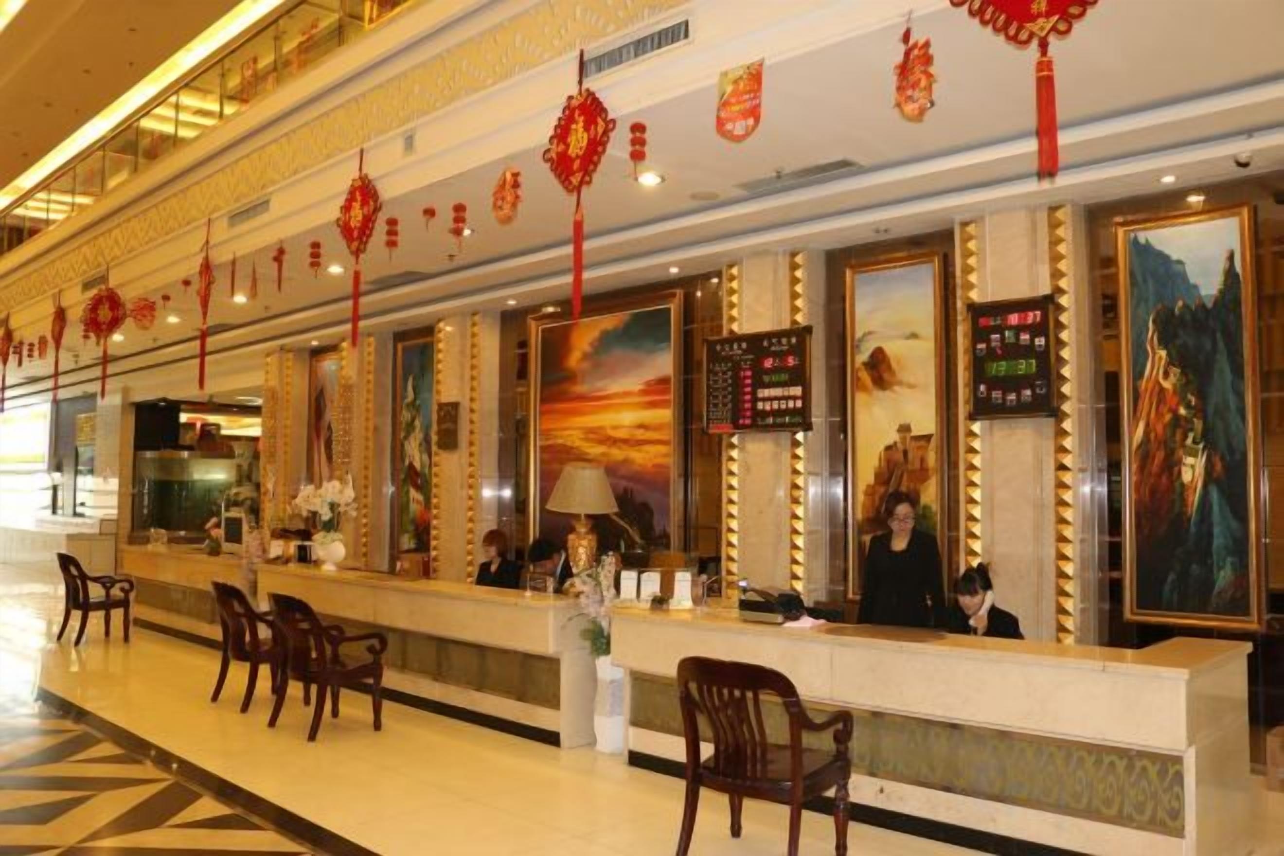 A hotel reception area with a long counter, chairs, and decorative lanterns.