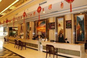 A hotel reception area with a long counter, chairs, and decorative lanterns.