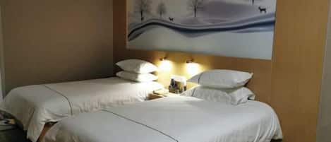 Habitación de hotel con dos camas, una mesita de noche y un cuadro colgado en la pared que representa un paisaje.