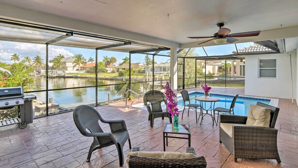 An outdoor patio with a pool, wicker furniture, and a grill. - Marco Island Home w/ Pool Near Tigertail Beach! (Marco Island)