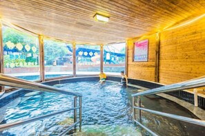 Ein Hallenbad mit Holzboden und Metallgeländern.