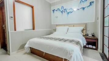 A bedroom with a bed, a nightstand, a wall-mounted painting, and a door.