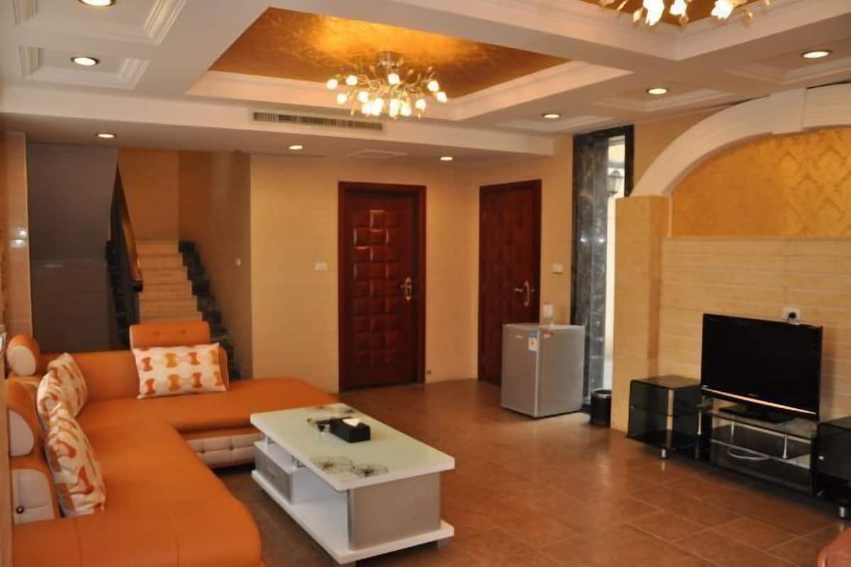 A living room with a sofa, a coffee table, a television, and a fireplace.