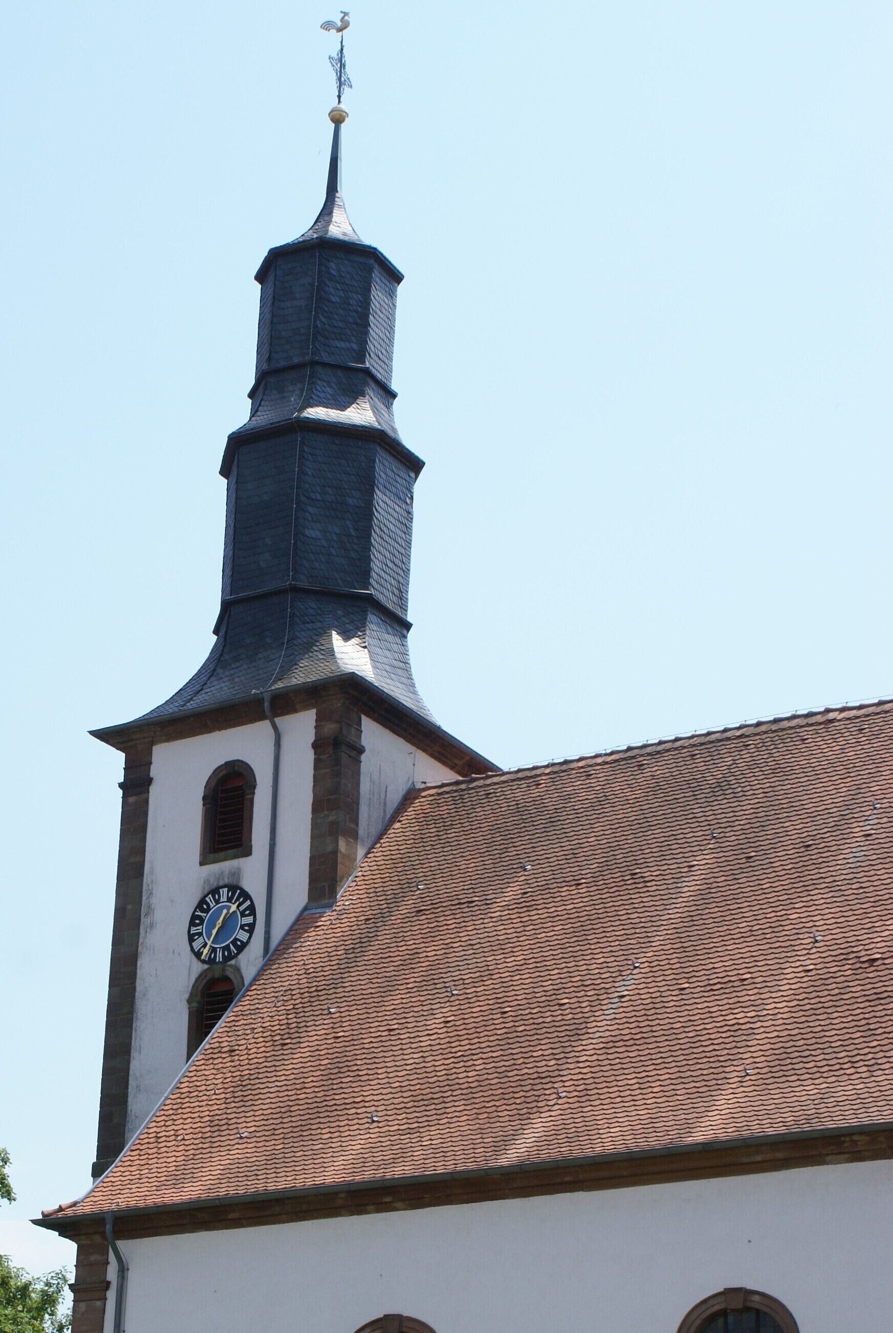 A church with a clock tower and a tiled roof.