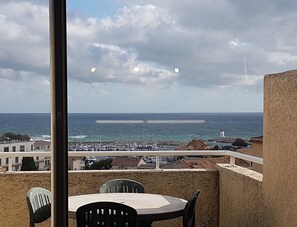 Enjoy breathtaking sea views from this balcony, featuring a round table and two chairs.