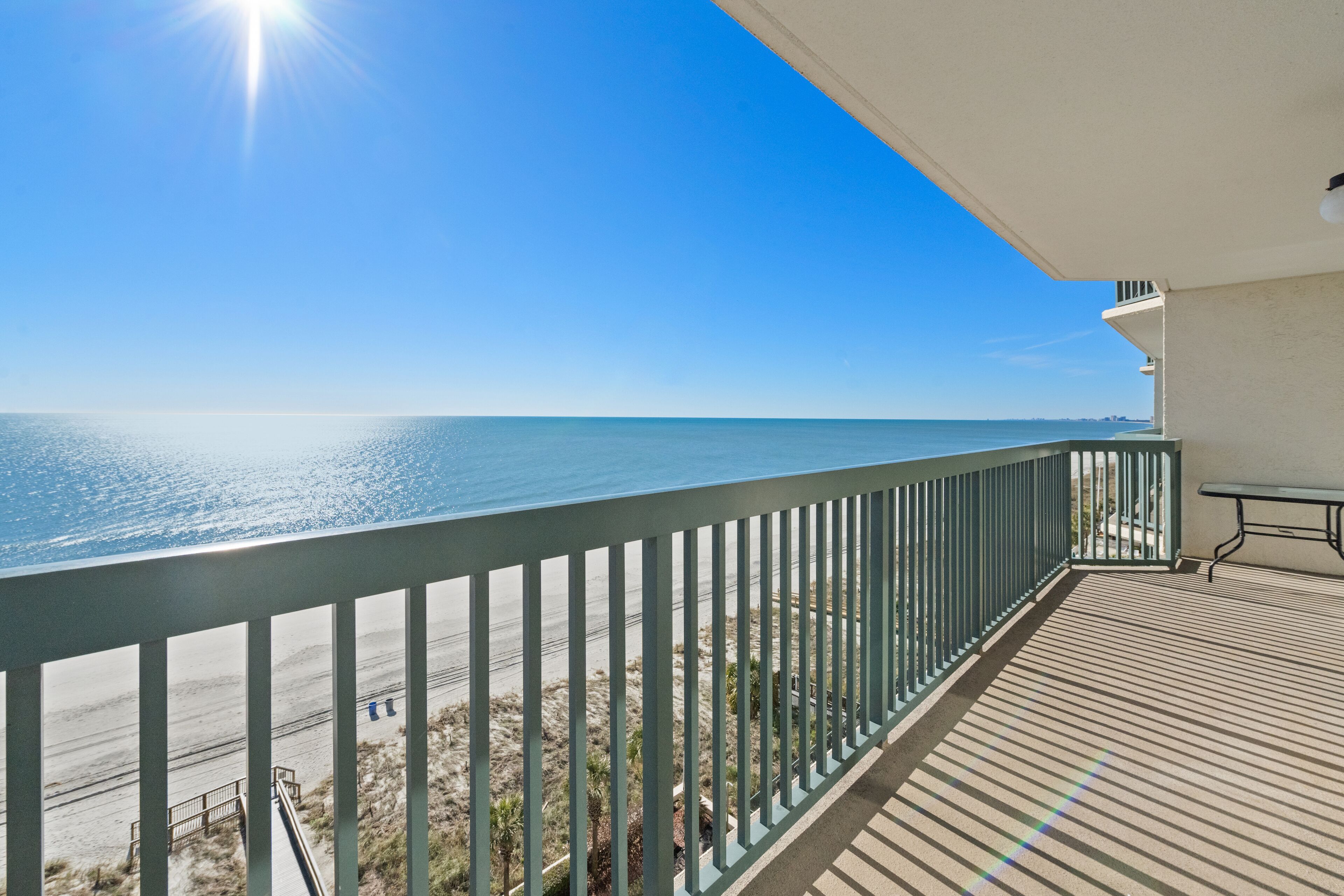 Ein Balkon mit Blick auf Strand und Meer.