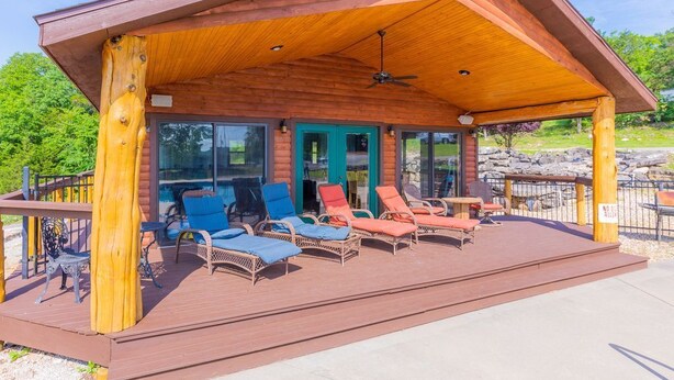 A covered outdoor area with lounge chairs and a wooden deck. - Sleeps 16-Marina, Pool, Roaring River & Table Rock (Cassville)