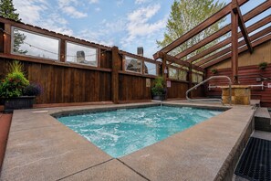 A wooden deck with a hot tub, a wooden fence, and a window overlooking a landscape. - Sundowner Last Run Condo: Ski-In, 2 Blocks To Main St (Breckenridge)