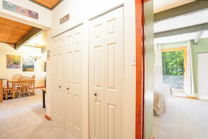 A room with a bed, a window with curtains, a door, and a dining area with chairs and a table. - Sundowner Last Run Condo: Ski-In, 2 Blocks To Main St (Breckenridge)