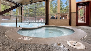 Zona de hidromasaje con vistas a la piscina, amplias ventanas y una puerta de madera.