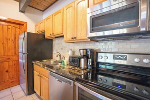 A kitchen with wooden cabinets, a stainless steel refrigerator, a microwave, a toaster, and a dishwasher. - Sundowner Last Run Condo: Ski-In, 2 Blocks To Main St (Breckenridge)
