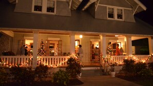 A two-story house with a porch decorated with Christmas lights and a Christmas tree. - Fort Myers Luxury Vacation Condo (Fort Myers)