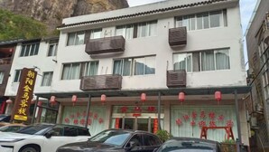 A hotel with a white facade, multiple balconies, and a signboard in a foreign language. - Jinmalou Hotel (Yueqing)