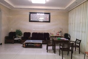 Una sala de estar con un conjunto de sofá, una mesa de centro y una mesa de comedor con sillas.
