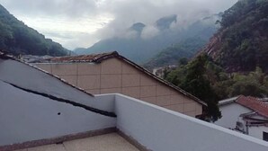 Vista d'una zona muntanyosa amb edificis i un teulat de teules.