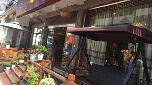 Ein Restaurant mit Außenbereich, Blumentöpfen und einer großen Markise.