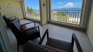 Un balcon avec vue sur l’océan et une chaise.