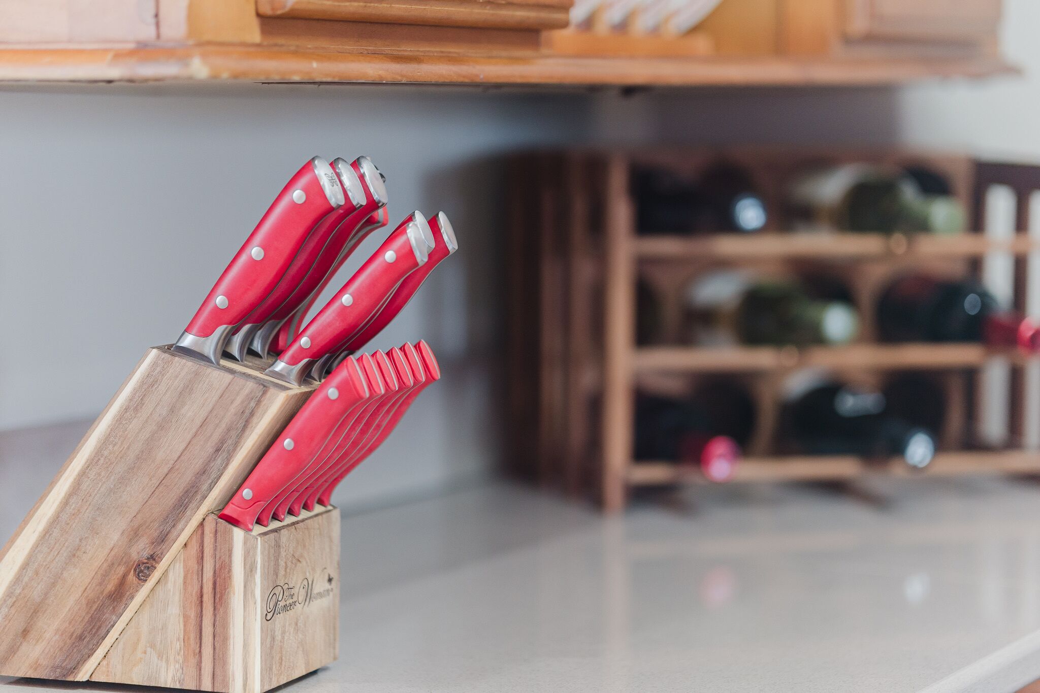 A wooden knife block with red-handled knives.