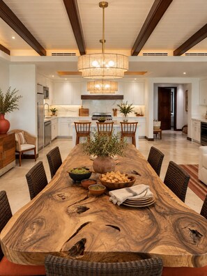 A spacious dining area with a large wooden table, multiple chairs, and a central chandelier. - Punta Mita Beachfront 5 Star Luxury (Punta de Mita)