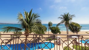 Un espace piscine offrant une vue sur la plage et l’océan.