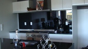 A kitchen with a large stove, a wine rack, and a coffee maker. - Waterviews and relaxation (Paihia)