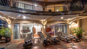 A spacious indoor area with multiple lounge chairs and a pool.
