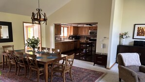 A spacious kitchen with wooden cabinets, a dining area with a large table and chairs, and a cozy living room with a sofa and a decorative rug. - 🌲☀️Private Lakefront prop. with Kayaks, Paddle boards, boat rental PVT dock☀️🌲 (Twin Lakes)