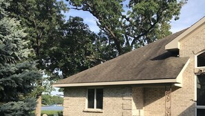 A residential house with a brick exterior, a sloped roof, and a front yard with a lawn and shrubs. - 🌲☀️Private Lakefront prop. with Kayaks, Paddle boards, boat rental PVT dock☀️🌲 (Twin Lakes)