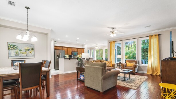 A spacious living area with hardwood floors, a dining table, and a kitchen in the background. - Awesome Decorated Lovely, Spacious Townhome by Isabella Golf Course!   (Hot Springs Village)