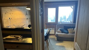 A cozy interior with a kitchen area, a dining table, and a sofa. - Resort center, app. 36 m2, 1 bedroom, mountain corner, balcony, ski room, WIFI (Morzine)