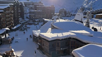 Een skioord bedekt met sneeuw, met houten gebouwen en een heldere lucht.