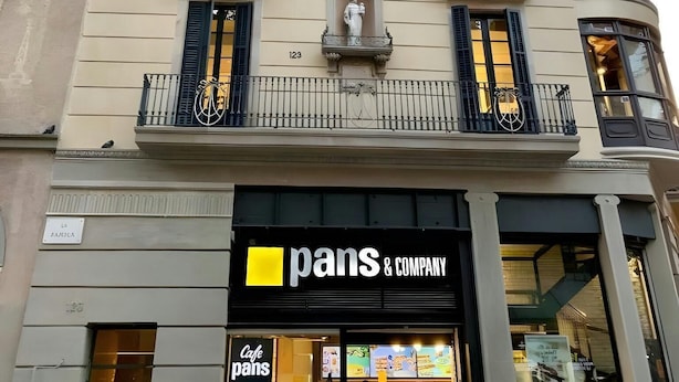 Un edificio con una cafetería llamada "pans & company" en la planta baja.