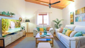 A living room with a TV, sofa, coffee table, and decorative items. - SON LLANERAS VILLA - NEAR ES TRENC, MALLORCA, RELAXING GETAWAY, POOL, A/C, WIFI (Campos)