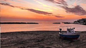 A boat on a sandy shore with a sunset in the background. - Villa on the Diamante beach  (Belvedere Marittimo)