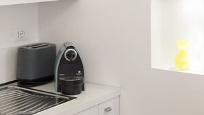 A kitchen with a toaster, coffee maker, and a window with a yellow vase. - Luxury apartment in the heart of Rome - Spanish Steps, wi-fi, a / c, (Roma)
