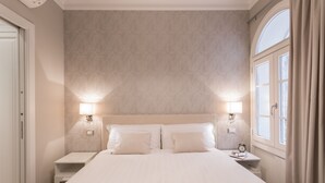 A bedroom with a large bed, two bedside tables, a nightstand, a window with curtains, and a wall clock. - Luxury apartment in the heart of Rome - Spanish Steps, wi-fi, a / c, (Roma)