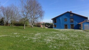 Un edificio a due piani con tetto piatto e un'estensione del tetto in tegole rosse.
