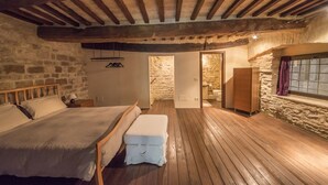 A cozy bedroom with a wooden bed, a bench, stone walls, and a wooden ceiling. - Loft in the center of Assisi (Assisi)