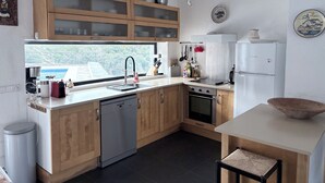 A modern kitchen with wooden cabinets, a dishwasher, a stove, and a refrigerator.