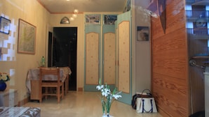 A room with a wooden wardrobe, a dining table with chairs, a vase with flowers, and a map on the wall. - CHAMONIX superb stud 2/3 pers, private residence, parking, ski lift access (Chamonix-Mont-Blanc)