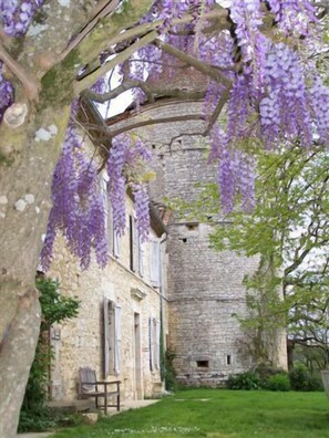 Un bâtiment en pierre doté d’une allée couverte et d’un banc.