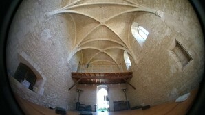 Une vue circulaire de l’intérieur d’une cathédrale, avec un plafond voûté élevé, de nombreuses fenêtres et une nef centrale menant à un espace ouvert.
