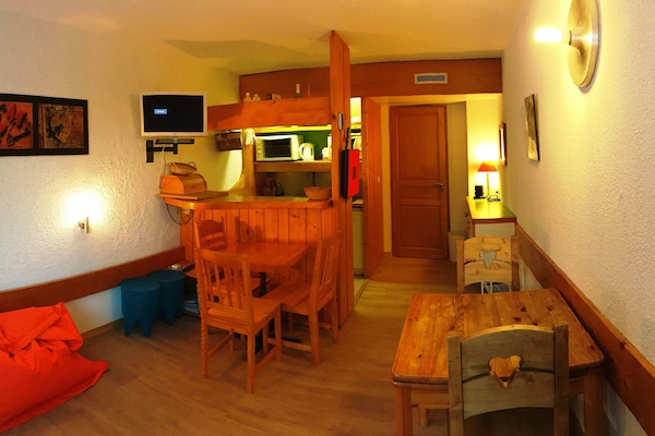 Pièce principale avec canapé lit et cuisine américaine